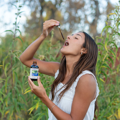 Woman outdoors with a bottle of Nature's Way product