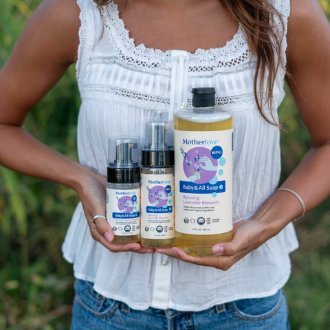 Person holding Mothercare baby products in a natural setting