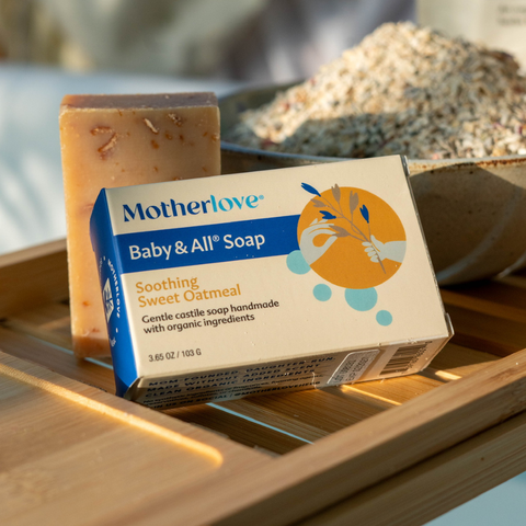 Bar soap with a sponge and oats in background on a tray over the bath