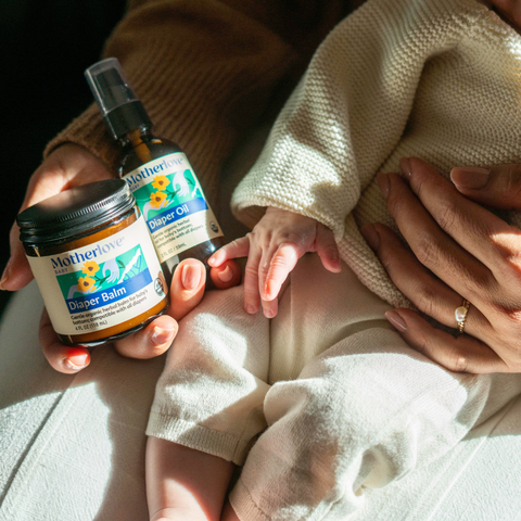 Mom holding baby and Diaper Balm and Diaper Oil